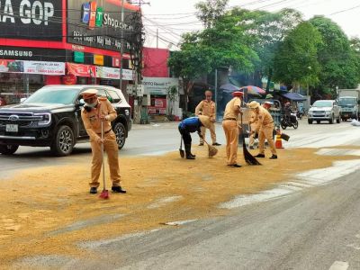 Cảnh sát giao thông dọn vết dầu loang cho người dân lưu thông an toàn